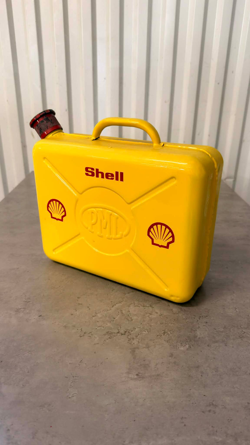 En svart bensindunk från DRH Customs med handtag och säkerhetslock, tillverkad av plast.