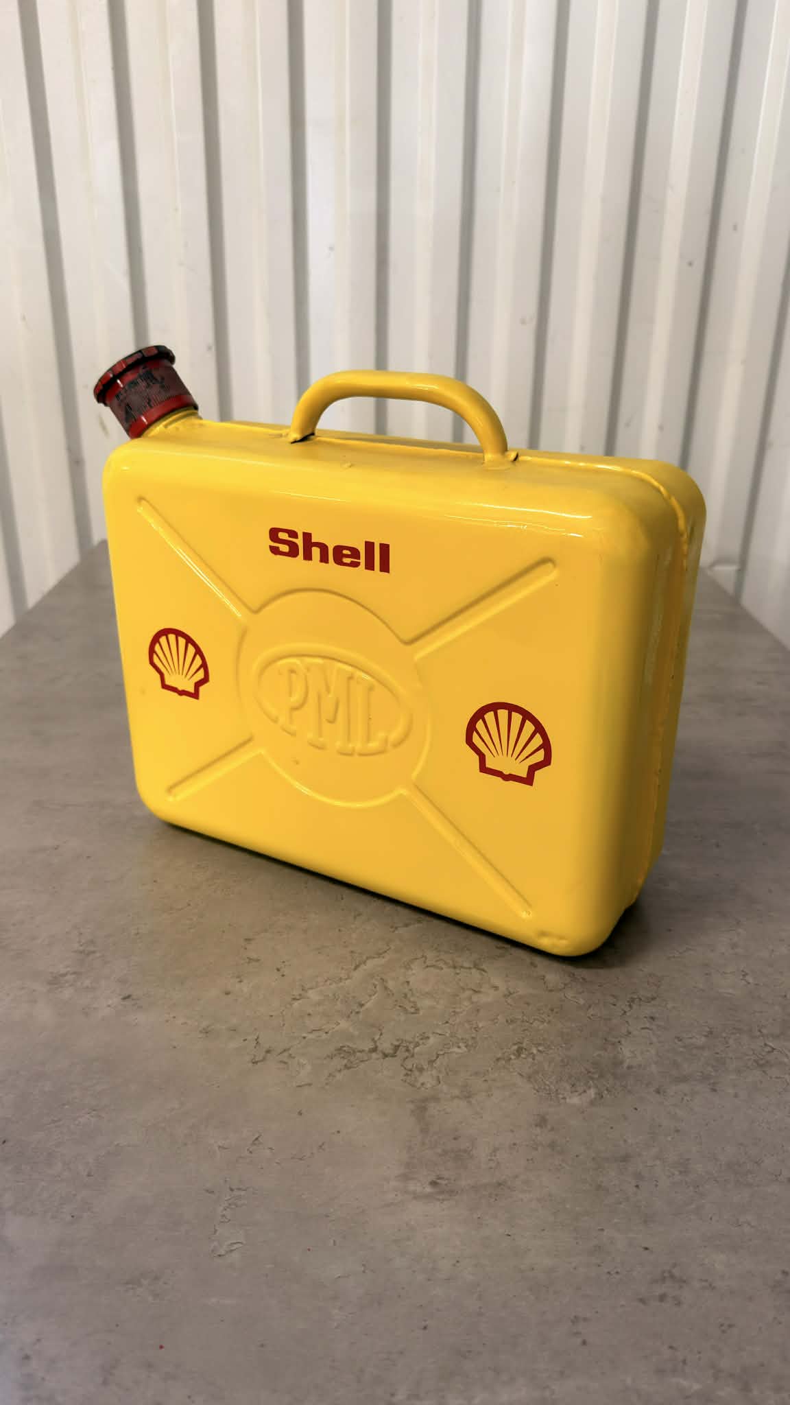 En svart bensindunk från DRH Customs med handtag och säkerhetslock, tillverkad av plast.